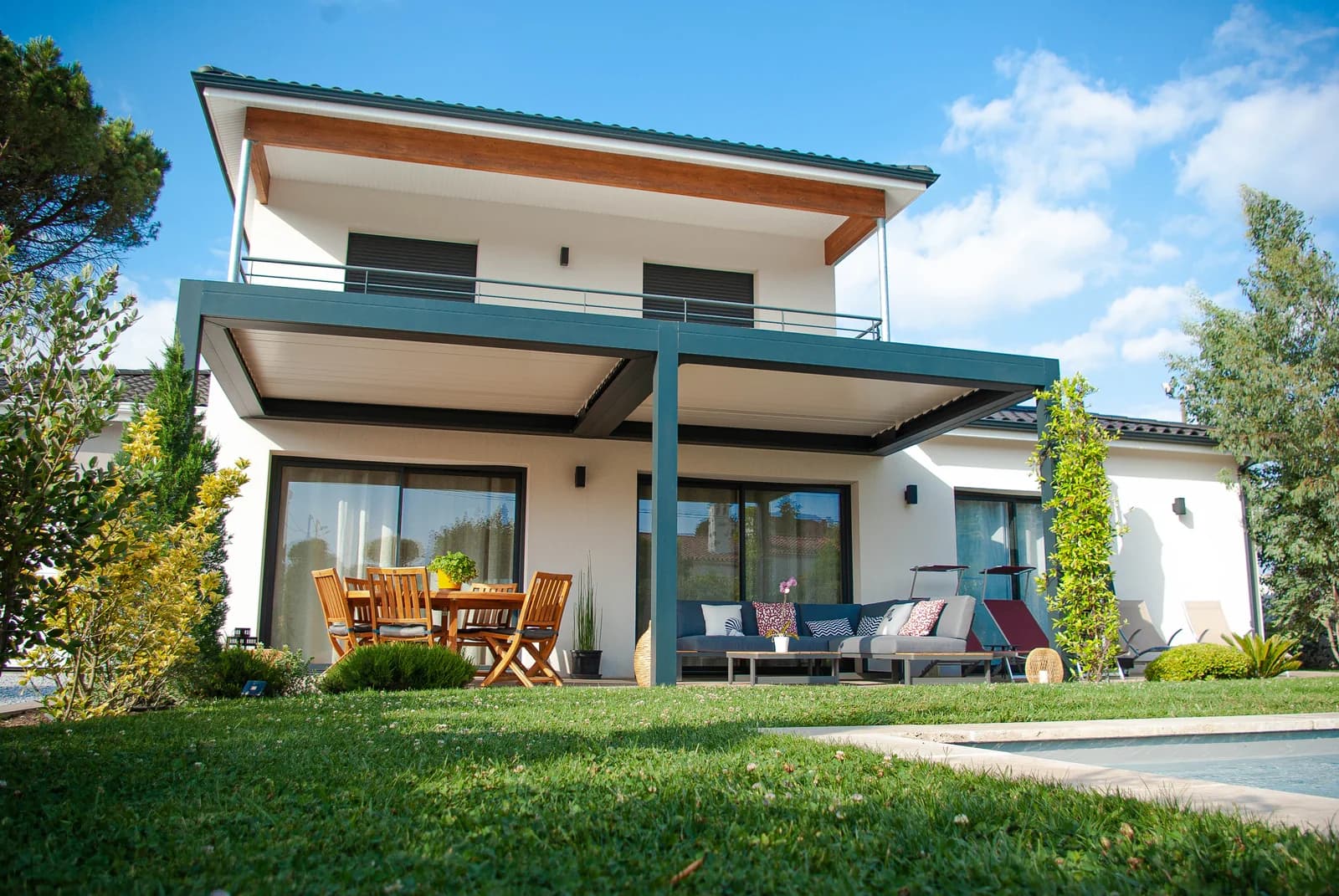 Maison CELIA à étage ouverte sur une terrasse couverte, un jardin et une piscine.
