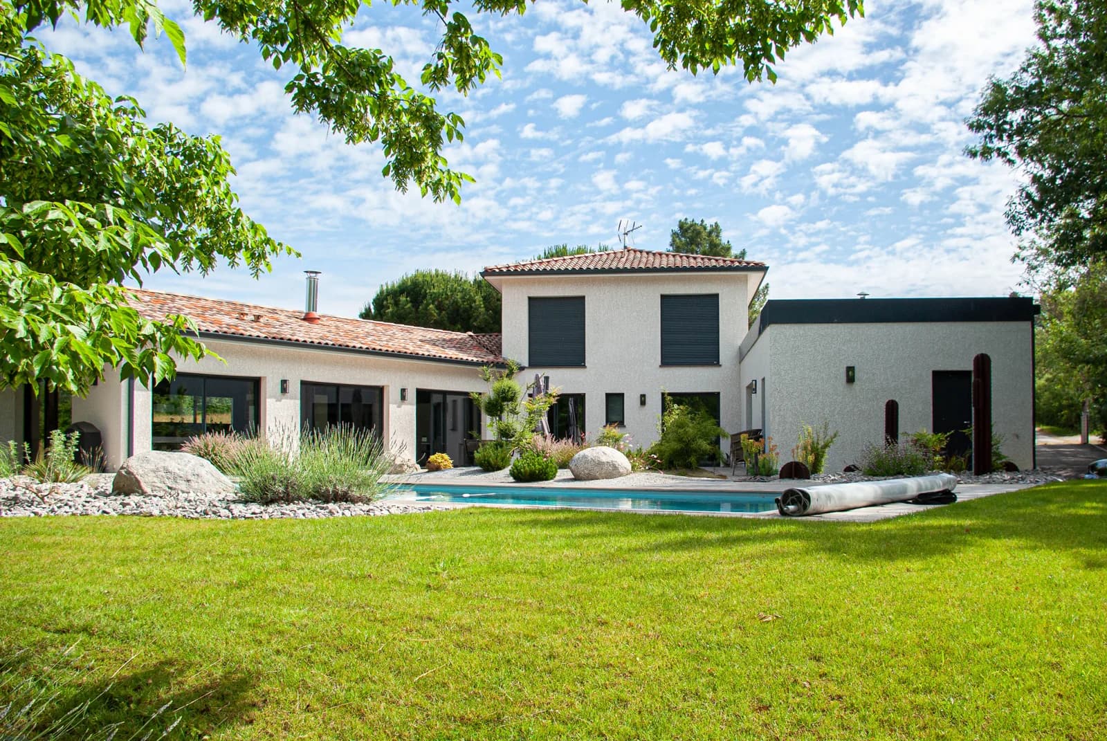 Maison CELIA associant un volume central à étage, deux ailes de plain-pied et un jardin arboré.