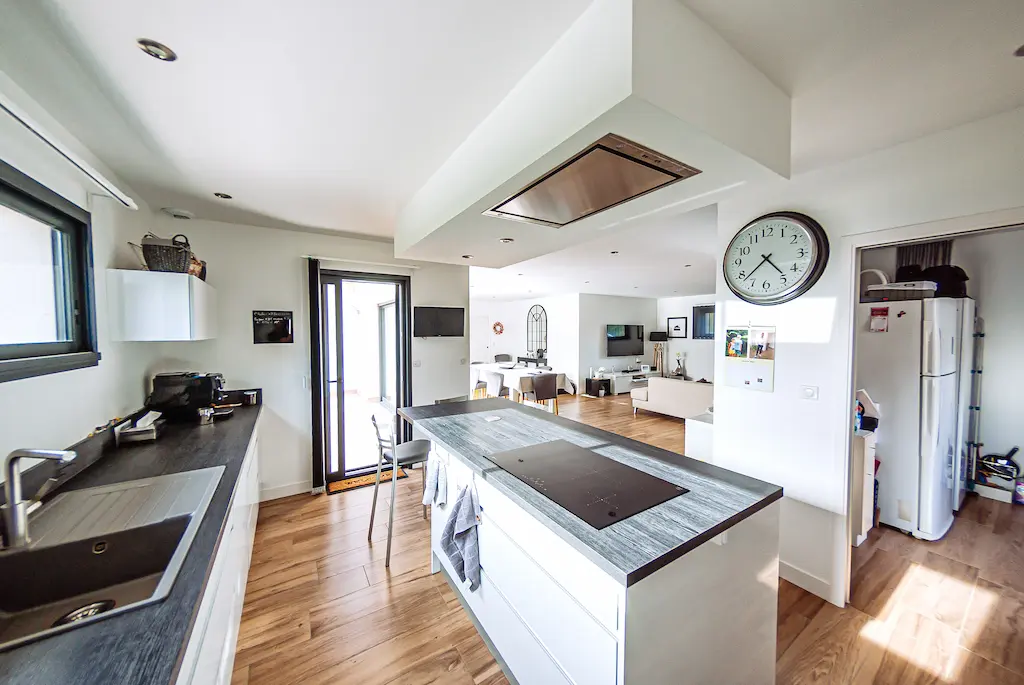 Cuisine ouverte et lumineuse dans une maison familiale.
