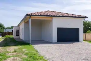 Maison moderne de plain-pied avec garage réalisée par CELIA Création à Plaisance du Touch, au style contemporain et toiture tuiles rouges.