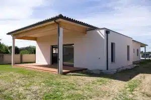 Vue sur la terrasse en bois d'une maison contemporaine de plain-pied réalisée par CELIA Création à Plaisance du Touch, avec toiture tuiles et lignes épurées.