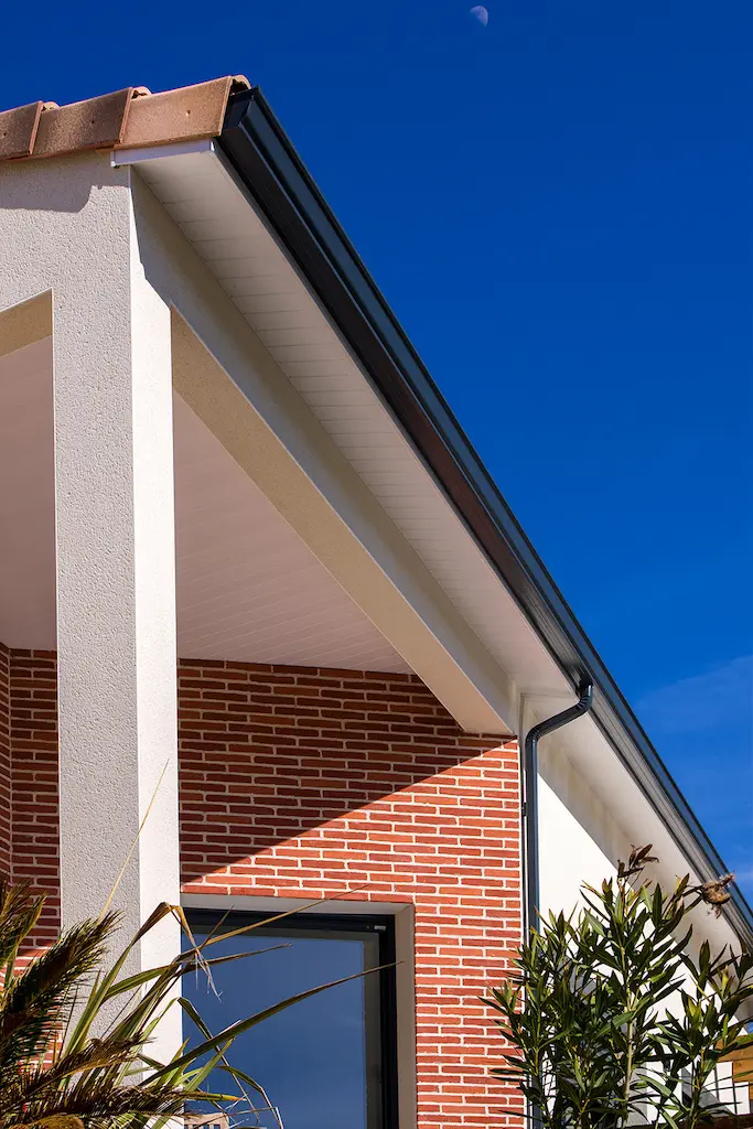 Détail architectural d’une maison moderne avec briques et toiture tuiles réalisée par CELIA Création à Rouffiac-Tolosan en Haute-Garonne