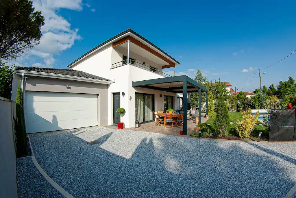 Maison contemporaine à étage avec garage et terrasse couverte réalisée par CELIA Création à Castelmaurou, maison familiale sur-mesure avec jardin et piscine.