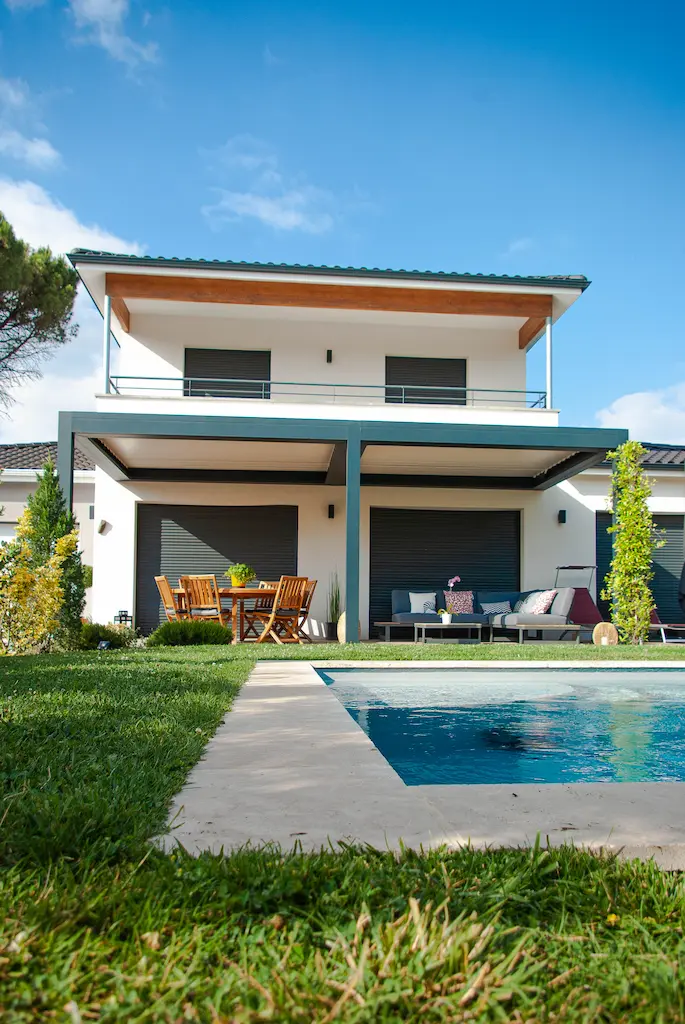 Maison contemporaine à étage avec piscine réalisée par CELIA Création à Castelmaurou, maison familiale sur-mesure avec terrasse couverte et grandes baies vitrées.