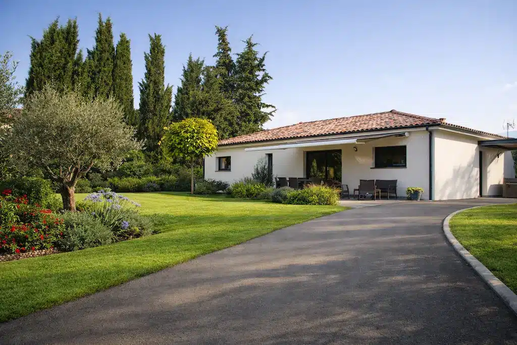 Maison moderne de plain-pied avec jardin paysager et terrasse à Toulouse réalisée par CELIA Création, constructeur de maison individuelle sur-mesure.