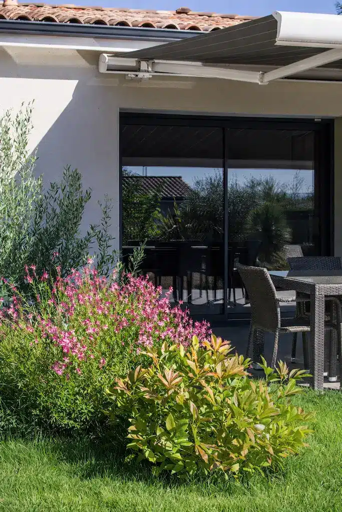 Baie vitrée donnant sur la terrasse d’une maison moderne de plain-pied de 130 m² à Toulouse réalisée par CELIA Création, constructeur de maison individuelle sur-mesure.
