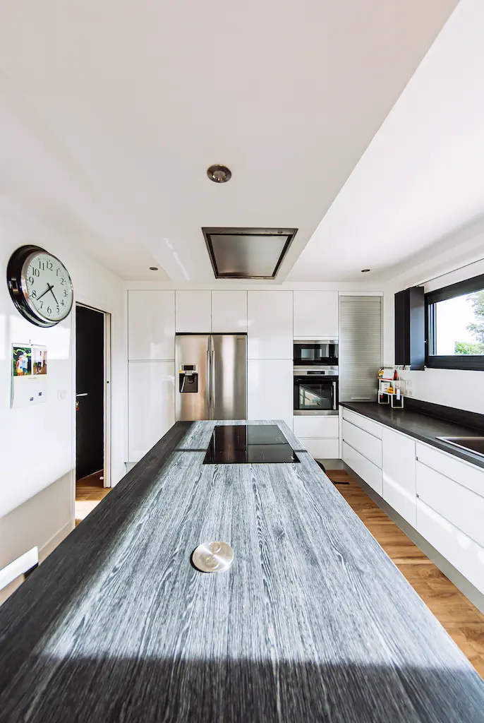 Cuisine moderne avec grand îlot central dans une maison de plain-pied réalisée par CELIA Création à Lapeyrouse-Fossat en Haute-Garonne