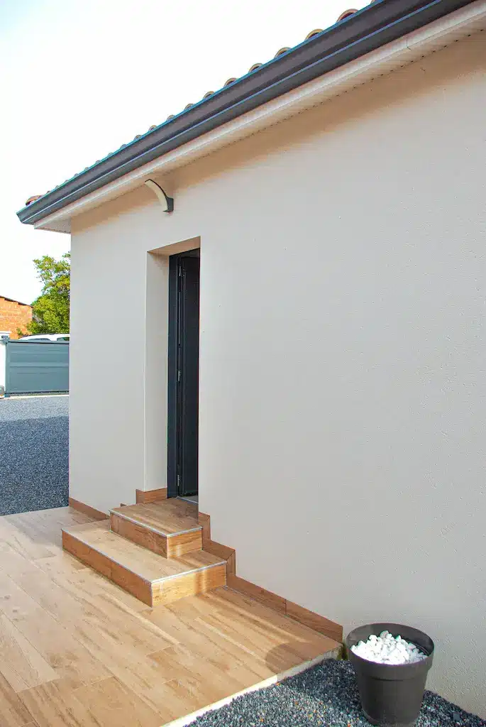 Entrée secondaire avec marches carrelées d’une maison de plain-pied réalisée par CELIA Création à Lapeyrouse-Fossat en Haute-Garonne
