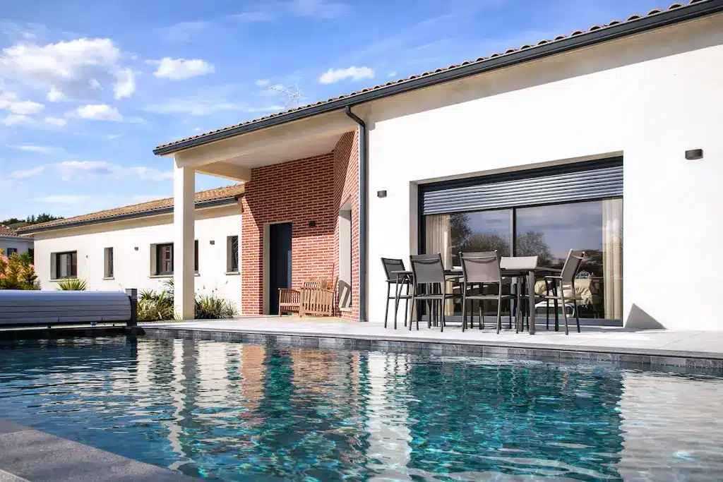 Terrasse avec piscine d’une maison moderne de plain-pied réalisée par CELIA Création à Rouffiac-Tolosan en Haute-Garonne