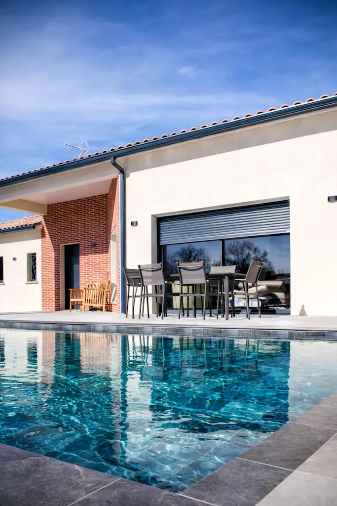 Piscine et terrasse d’une maison moderne de plain-pied réalisée par CELIA Création à Rouffiac-Tolosan en Haute-Garonne