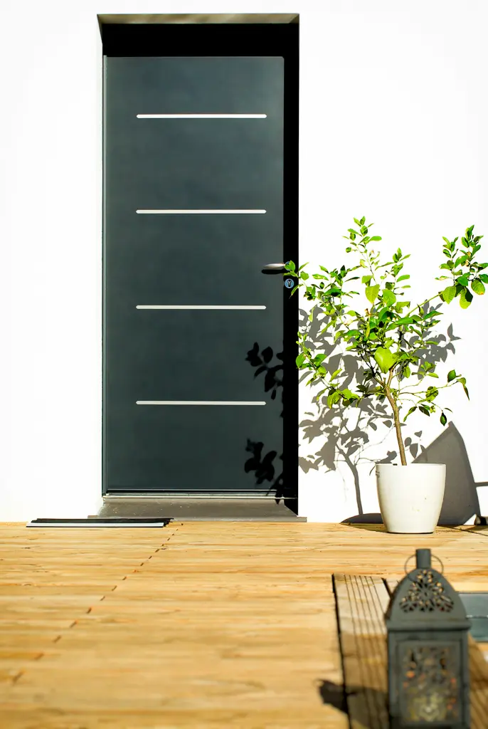 Porte d’entrée moderne d’une maison de plain-pied avec terrasse bois réalisée par CELIA Création à Tournefeuille en Haute-Garonne