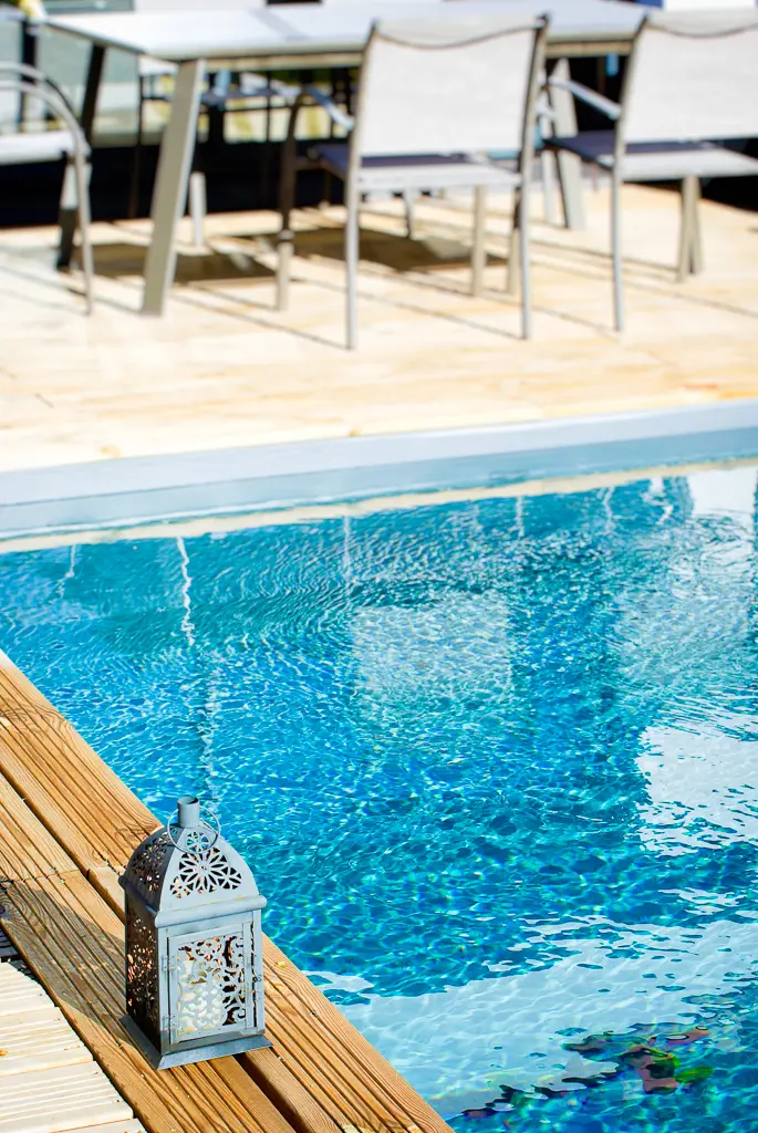 Détail de la piscine et de la terrasse en bois d’une maison moderne de plain-pied réalisée par CELIA Création à Tournefeuille